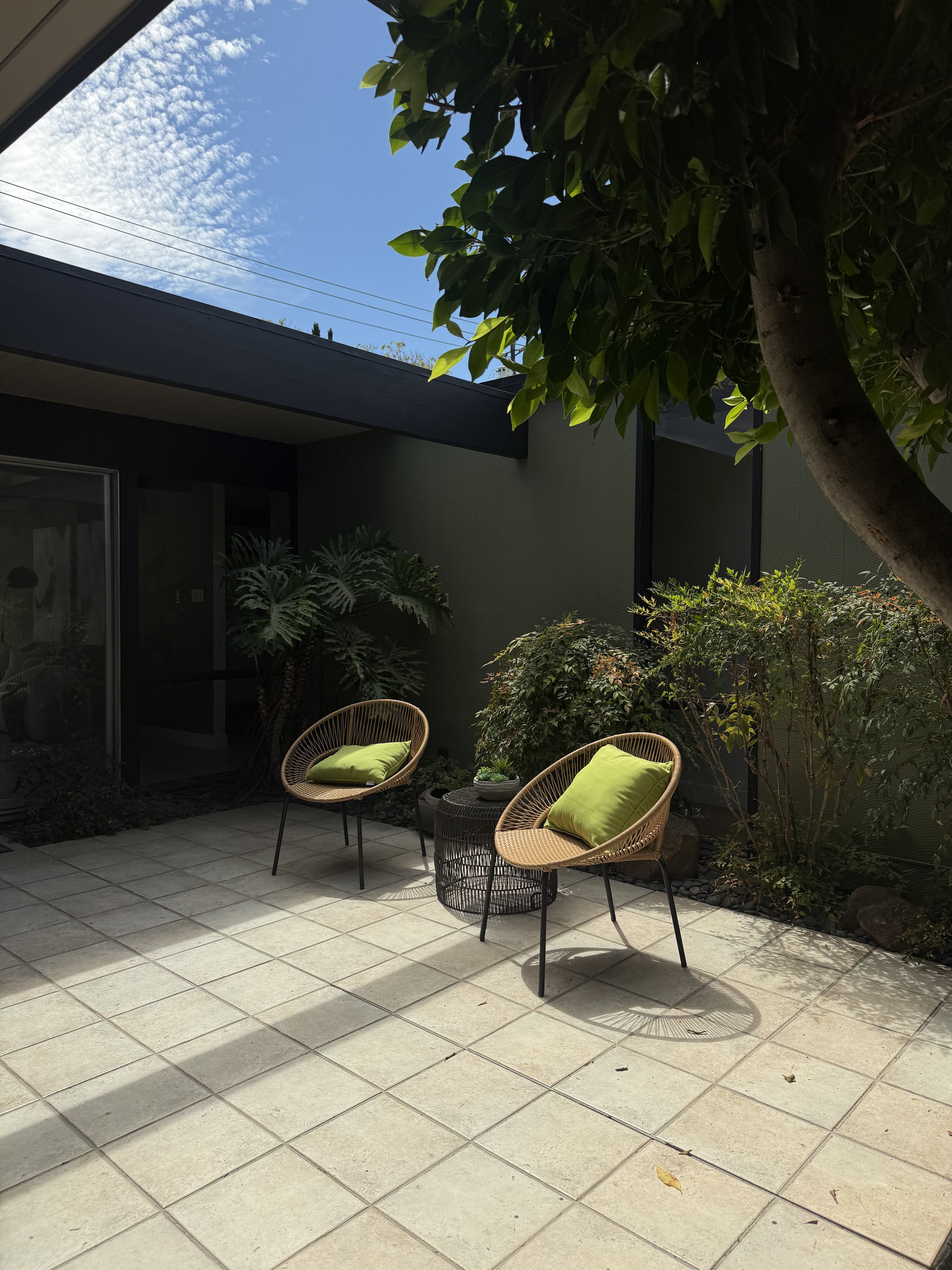 Private courtyard patio with lounge chairs, tucked beside a mid-century home