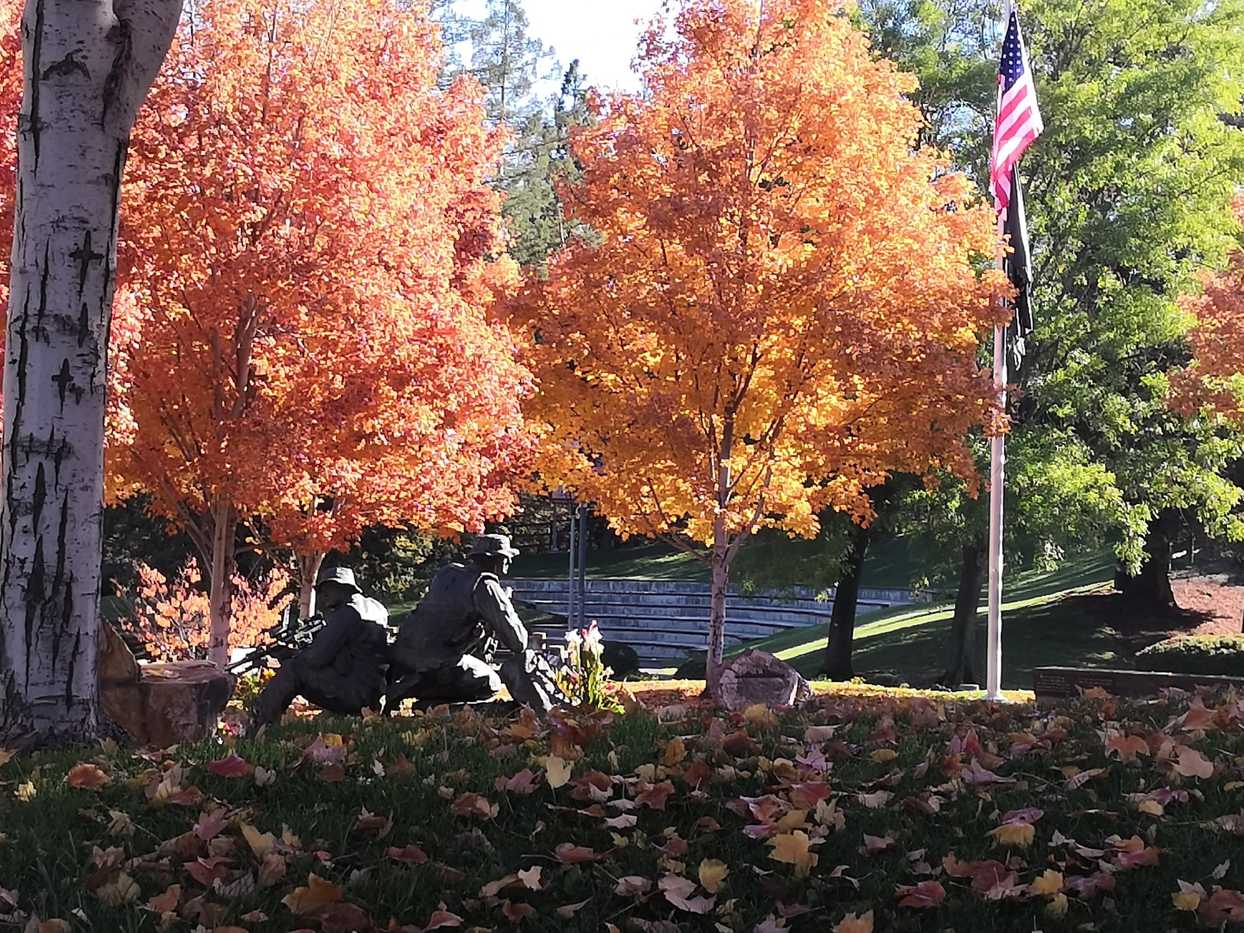 Orange and red fall trees around a statue in Cupertino's Memorial Park